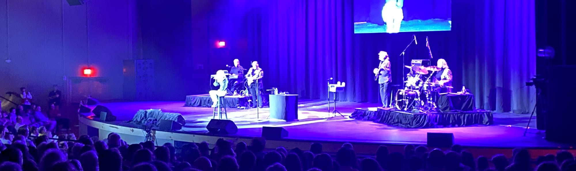 signer on stage in chair washed out by the lights Lexington